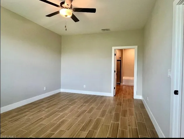 Empty room with wood tiled floors and ceiling fan