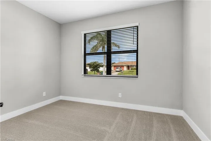 Spare room featuring light carpet and baseboards