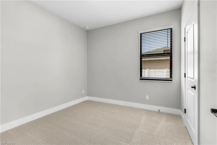 Spare room featuring light colored carpet and baseboards