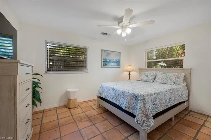 Tiled bedroom 2 with multiple windows and ceiling fan