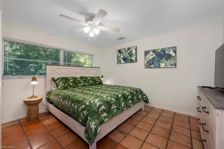 Bedroom with dark tile patterned flooring and ceiling fan
