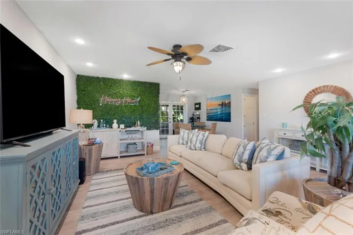 Living room with ceiling fan and light hardwood / wood-style flooring