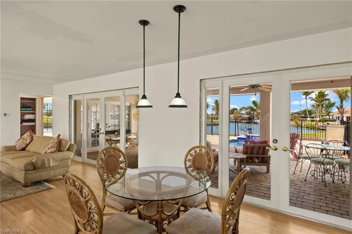 Dining room featuring a water view, light wood-type flooring, and french doors