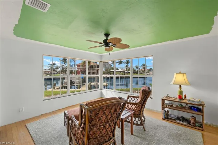 Sunroom with a water view and ceiling fan