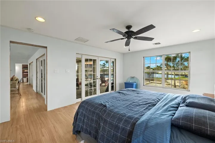 Bedroom featuring light wood-type flooring, french doors, access to outside, and ceiling fan
