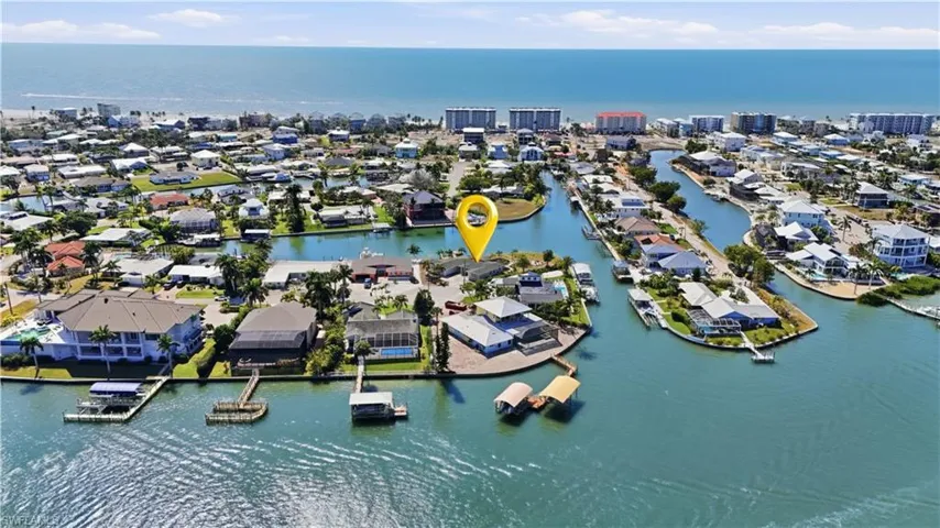 Aerial view of property and surrounding area with a large body of water and nearby suburban area - Virtually Edited Image