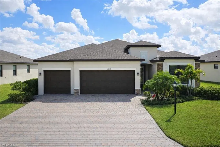 Prairie-style home with a garage, a front yard, roof with shingles, and stucco siding