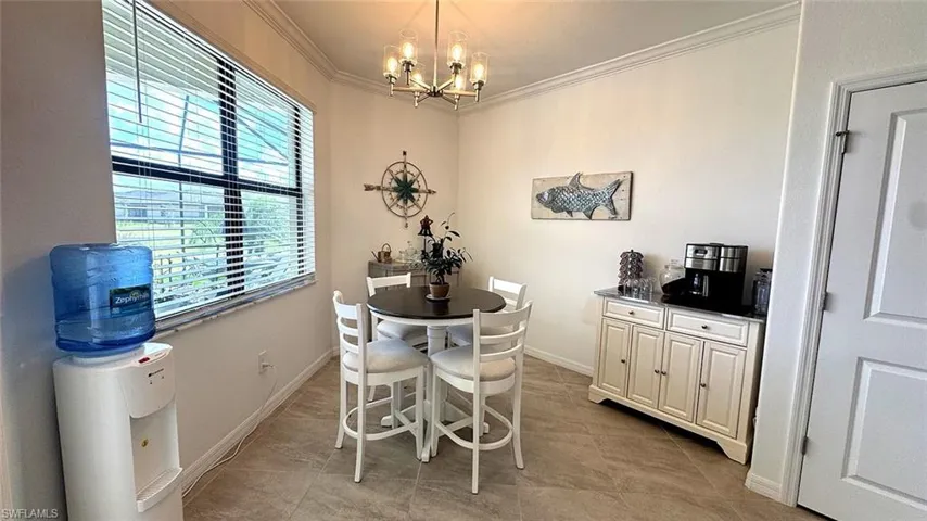 Dining room featuring crown molding, suspended lighting, and light tile patterned floors