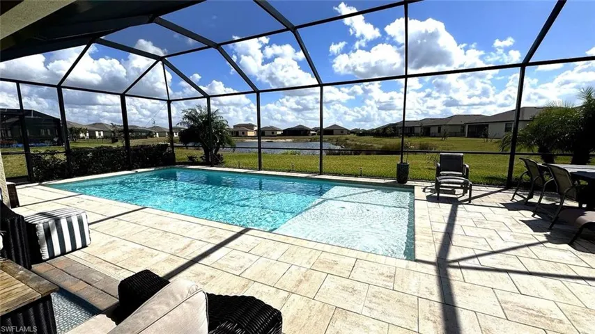 Swimming pool featuring a residential view, a lawn, a sunroom, and a lanai