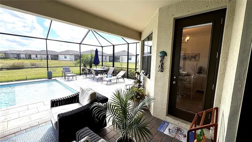 View of patio / terrace with a sunroom, an outdoor pool, a lanai, and a residential view