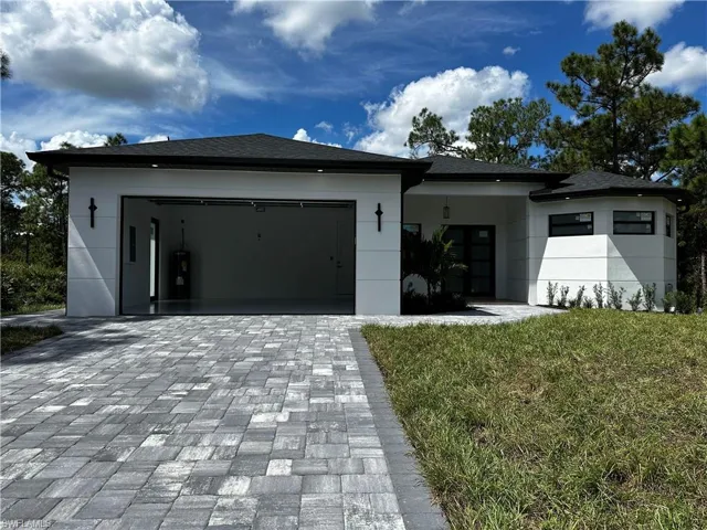 View of front facade featuring a front yard and a garage