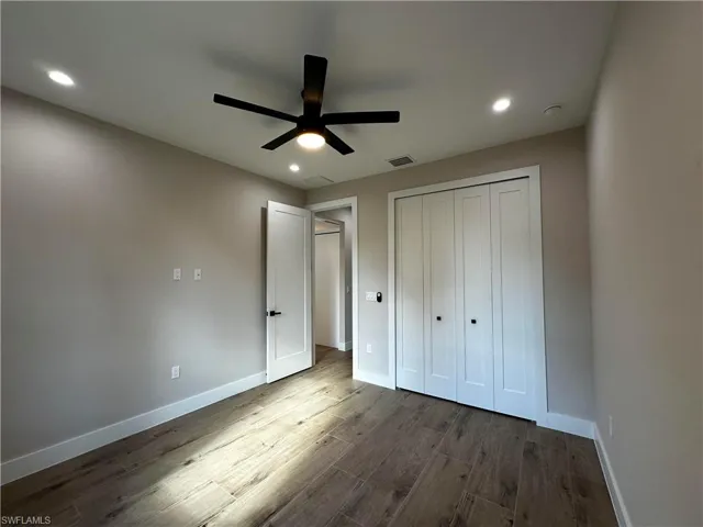 Unfurnished bedroom featuring a closet, ceiling fan, and dark hardwood / wood-style flooring