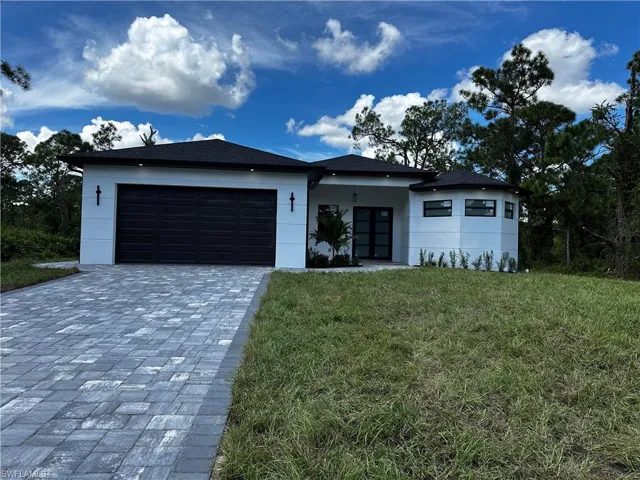 View of front of property featuring a front yard and a garage