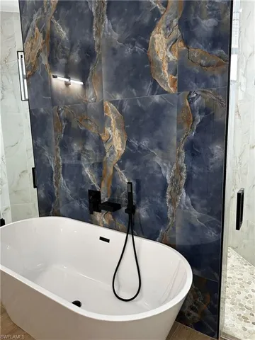 Bathroom featuring independent shower and bath, tile walls, and wood-type flooring