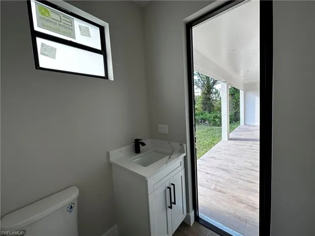 Bathroom with wood-type flooring, vanity, and toilet