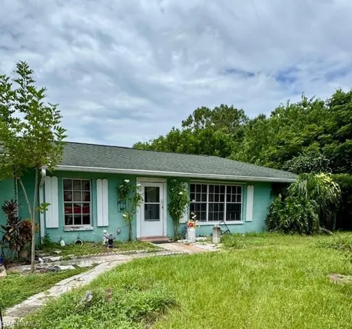 Single story home featuring stucco siding, a front lawn, and roof with shingles