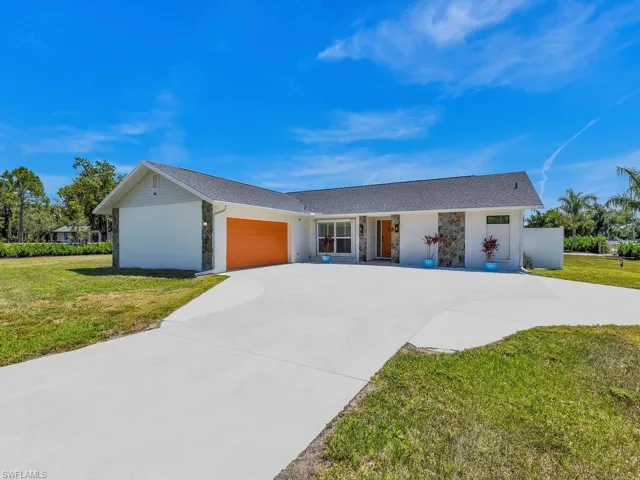 Ranch-style house featuring a garage and a front yard