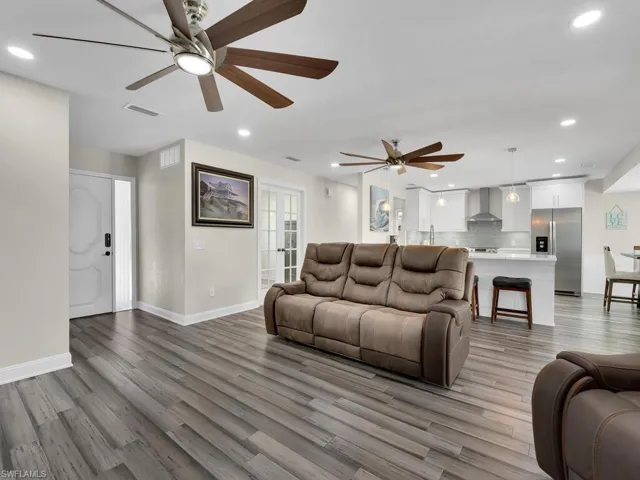 Living room with ceiling fan, sink, and light hardwood / wood-style floors