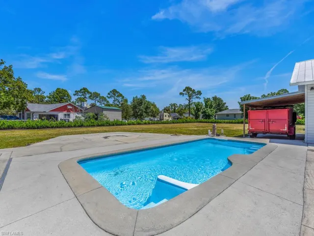 View of swimming pool featuring a patio and a lawn