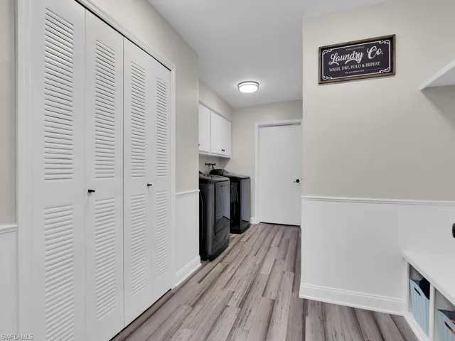 Clothes washing area featuring cabinets, light hardwood / wood-style floors, and hookup for a washing machine