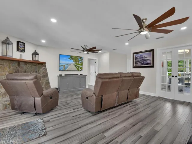 Living room featuring ceiling fan, french doors, and light hardwood / wood-style floors