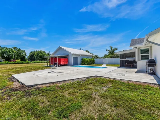 View of pool featuring an outbuilding, area for grilling, a yard, and a patio area