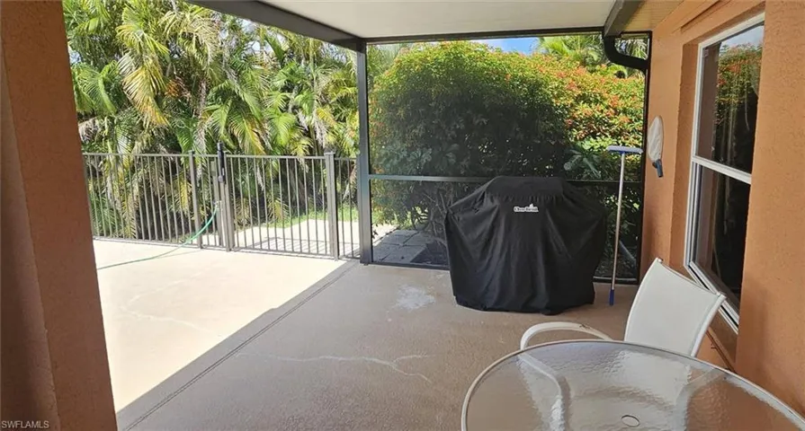 Screened patio featuring a concrete surface, a white-framed window, and a perimeter fence