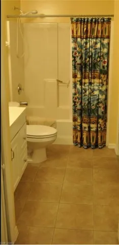 Bathroom featuring a white vanity with cabinet storage, a toilet, and a shower-tub combination