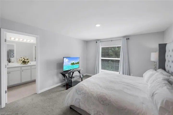 Bedroom with light colored carpet and baseboards