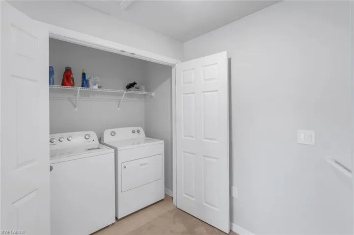 Washroom featuring separate washer and dryer and light tile patterned flooring