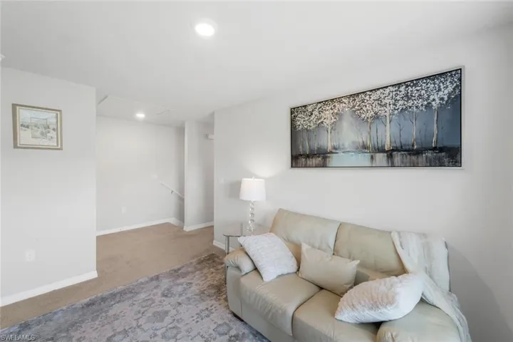 Carpeted living room with baseboards and recessed lighting
