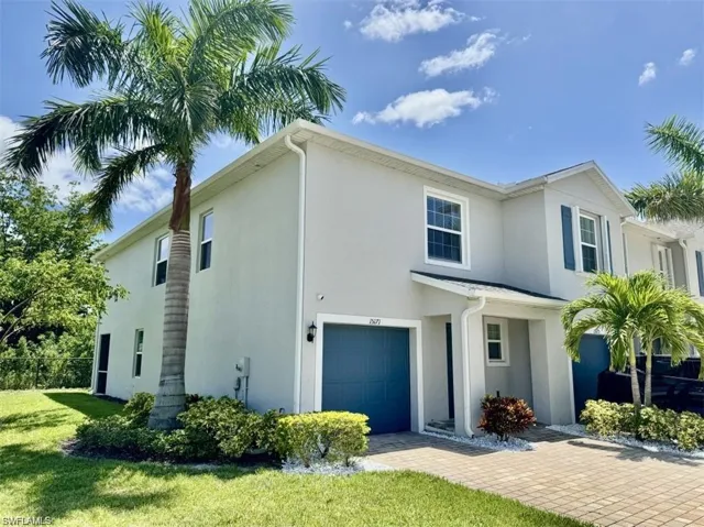 View of front of home featuring stucco siding, a garage, and a front yard