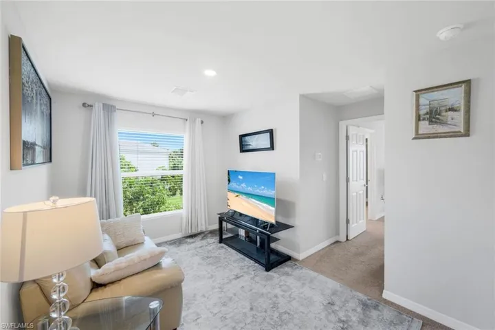 Carpeted living area with baseboards and recessed lighting