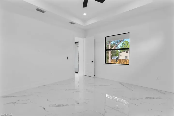 Spare room featuring a raised ceiling, recessed lighting, and a ceiling fan