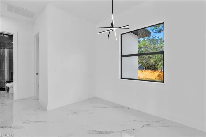 Spare room with baseboards and light marble finish floors