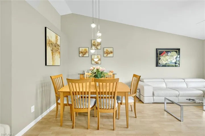 Dining area with lofted ceiling and light wood-type flooring