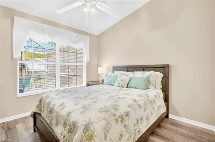 Bedroom featuring wood finished floors, vaulted ceiling, and ceiling fan