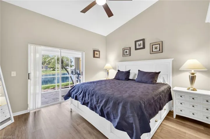 Bedroom featuring access to outside, wood finished floors, ceiling fan, and high vaulted ceiling