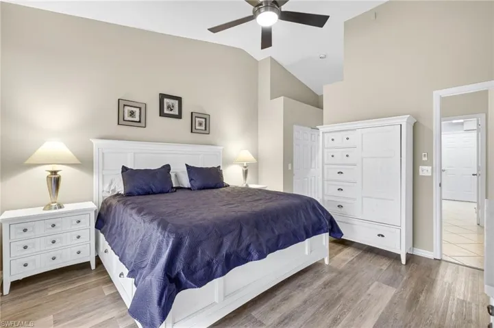 Bedroom featuring wood finished floors, high vaulted ceiling, and a ceiling fan