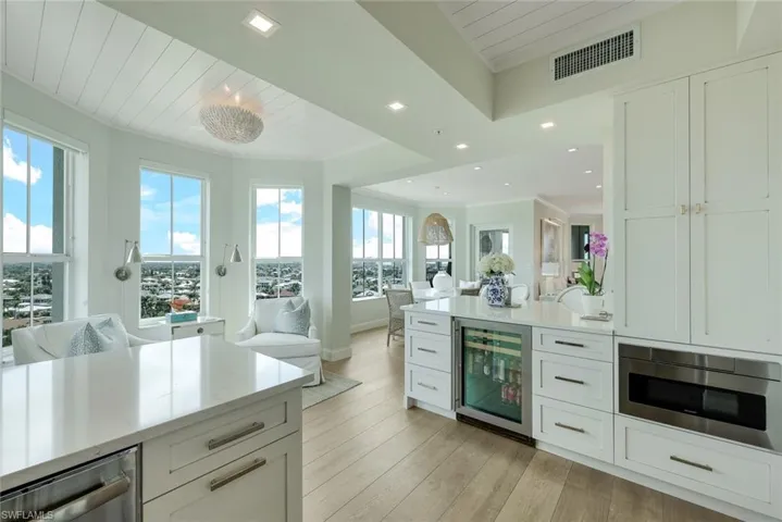 View from kitchen of seating, dining and city scape. Beautiful LED flat square recessed lighting throughout.