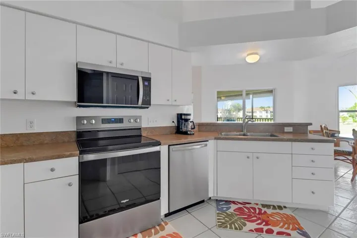 Kitchen featuring stainless steel appliances, sink, white cabinets, and kitchen peninsula