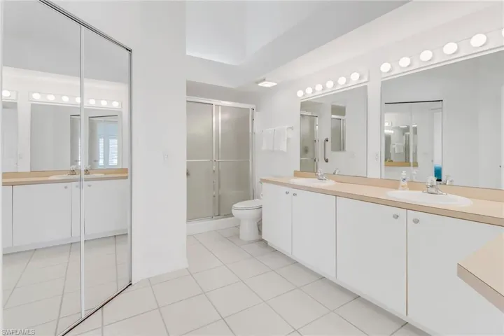 Bathroom featuring tile patterned floors, toilet, an enclosed shower, and vanity
