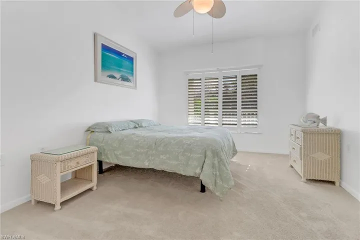 Carpeted bedroom featuring ceiling fan