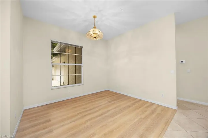 Empty room with light wood-style flooring and a chandelier