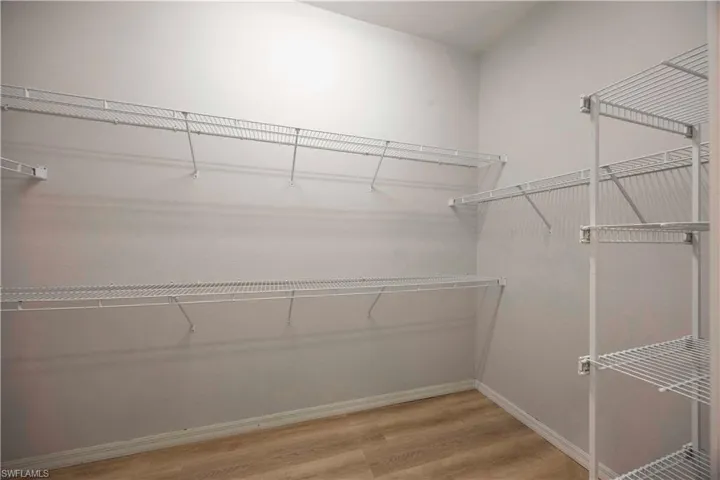 Spacious closet featuring light wood-style flooring