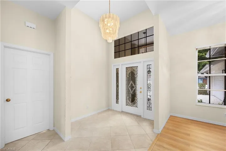 Entrance foyer featuring a chandelier, a high ceiling, and light tile patterned flooring