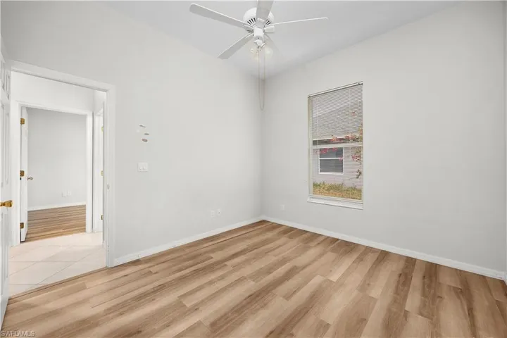 Empty room with light wood finished floors and ceiling fan