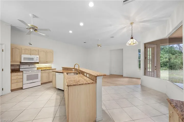 Kitchen featuring a ceiling fan, light tile patterned floors, white appliances, recessed lighting, and decorative light fixtures