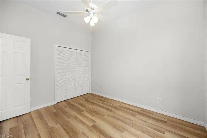 Unfurnished bedroom featuring light wood-style floors, a closet, and ceiling fan