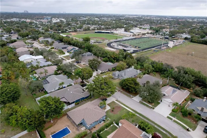 Aerial view of property and surrounding area featuring nearby suburban area